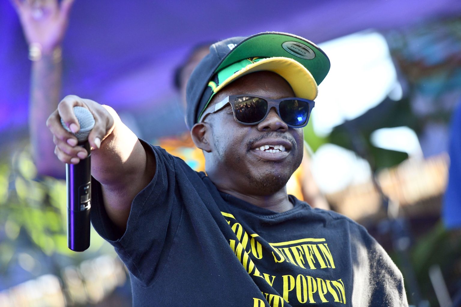 Rapper Bushwick Bill on stage with a mic in his hand, about to do a mic drop.